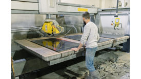 SW 1223 Worker standing at a CNC machine in a fabrication shop